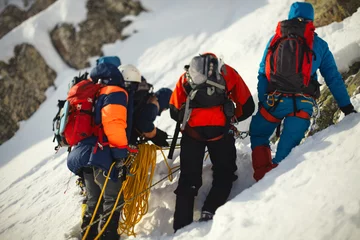 Papier Peint photo Lavable Alpinisme Grimpeurs de groupe sur une pente de montagne enneigée.
