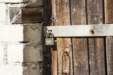 large heavy lock on the bolt of an old wooden door