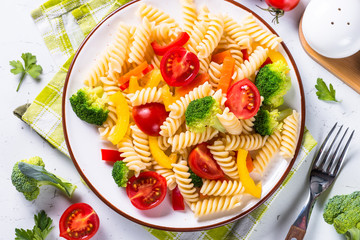 Vegan pasta fusilli with vegetables on white. 