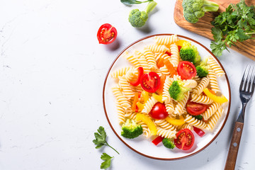 Vegan pasta fusilli with vegetables on white. 