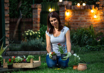 Beautiful mid age woman doing some gardening in her backyard