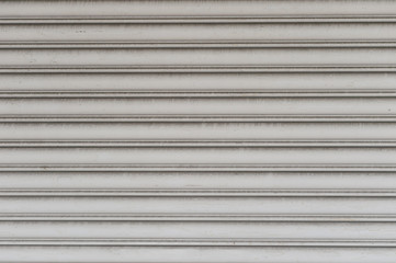 Obraz premium A closeup shot of automatic metal roller door used in factory, storage, garage, and industrial warehouse. The corrugated and foldable metal sheet offer space saving and provide urban and rustic feel