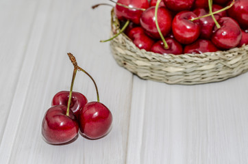 primer plano de cerezas sobre mesa de madera blanca 