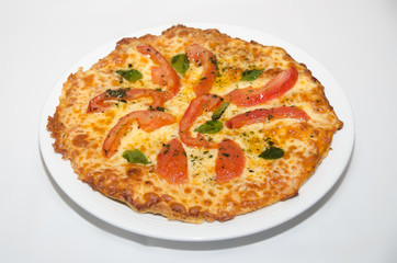Pizza with melted cheese and tomato slices
