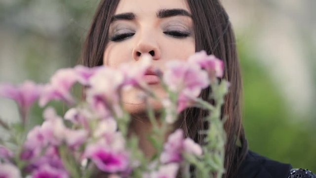 Sexy attractive woman sniff beautiful flowers in the garden