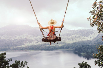 Fototapety  Beztroska kobieta na huśtawce w inspirującym krajobrazie.