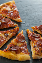 delicious fresh cooked slices of pepperoni pizza on slate