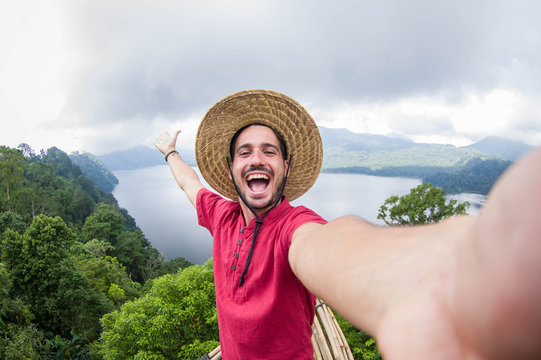 Crazy handsome man taking a selfie on a scenic landscape