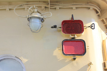 Old Vintage Lamp on Ship Deck Wall Industrial Ship Image. Bulkhead Light on Navy Ship against Retro Painted Wall Background. Industrial Light Bulb Lamp Detail on Deck Interior.