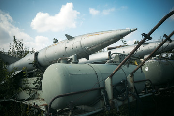 Air forces, aircraft, history, progress, development. Textured grunge old rocket launcher, blue sky background. Old rocket launcher in museum of aviation or garbage dump, recycling center.