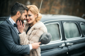 Just married couple at the black retro car on their wedding.