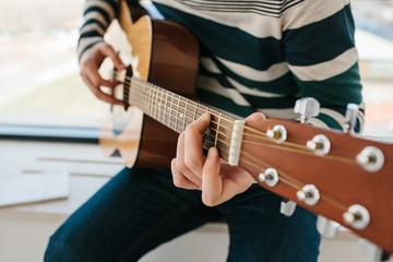 Obraz premium Learning to play the guitar. Music education and extracurricular lessons
