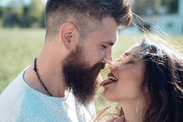 Lady with pink tongue licking bearded macho. Couple kissing outdoors, nature on background, close up. Kiss concept. Couple in love on happy faces relaxing and kissing with tongue.