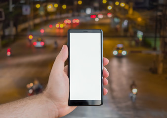Hand of man holding mobile phone on traffic jam