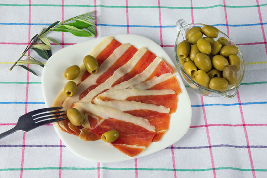 Balkan cuisine . Slices of prsut (dry-cured ham,  prosciutto)  and green olives