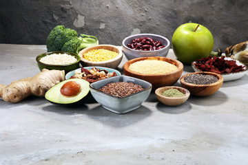 superfood concept on stone table with avocado, goji and nuts and seeds.