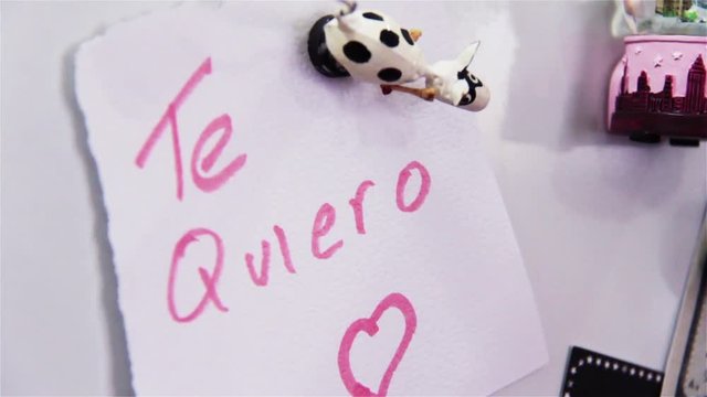 Woman Taking Out Love Letter in Spanish From the Refrigerator. Girl Making Decision To Break Up With Her Boyfriend. Female Hands Tear Paper with a Red Heart. Rupture Concept. Close-Up