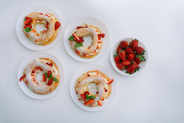 Cakes Paris Brest with strawberries, mint on white table