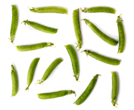 The pods of green peas are scattered on a white background.