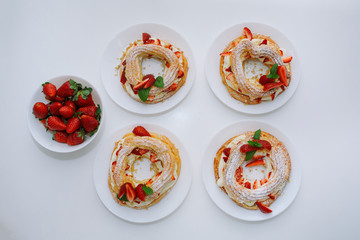 Cakes Paris Brest with strawberries, mint on white table
