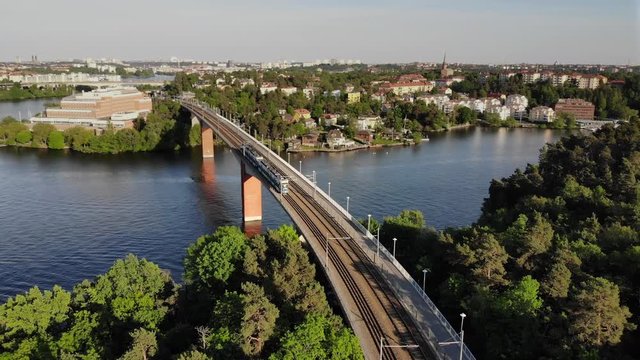 Aerial footage of the Stockholm island Stora Essingen and two tramway trains meeting on the bridge "Alviksbron", a part of "Tv&auml;rbanan"