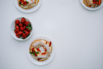 Cakes Paris Brest with strawberries, mint on white table