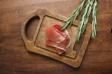 prosciutto jamon ham on a wooden background rosemary