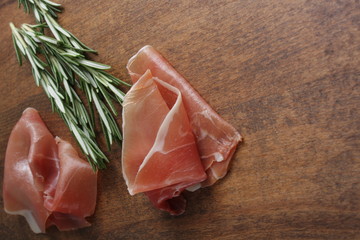 prosciutto jamon ham on a wooden background rosemary