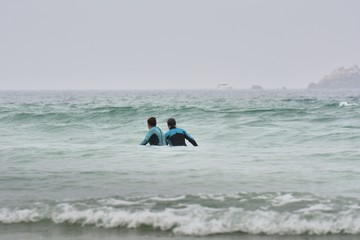 Un couple de seniors pratique le longe côte sur une plage de Bretagne