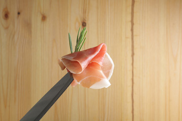 prosciutto jamon ham on a wooden background rosemary
