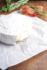cheese brie and prosciutto jamon ham wooden background rosemary