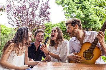 Fototapeta na wymiar group of young friends having fun singing a song