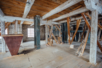 Fototapeta na wymiar Inside old abandoned wooden mill with old equipment