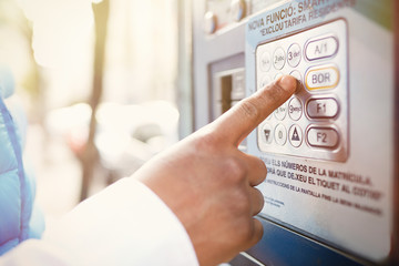 Closeup headshot of young African man trying to check balance on his credit card using automatic teller machine. Blurred background