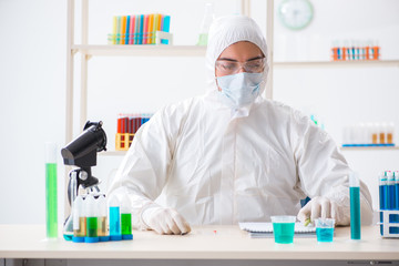 Young chemist student working in lab on chemicals