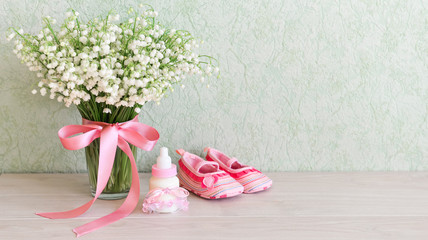 children's shoes are on the table near a bouquet of flowers. For a baby shower celebrate. for thematic birthday decor