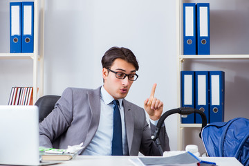 Businessman looking after newborn baby in office