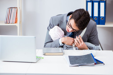 Businessman looking after newborn baby in office