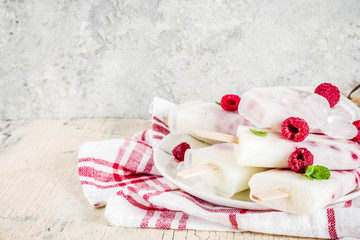 Summer sweet desserts, homemade organic ice cream popsicles from raspberry and yogurt, light beige background copy space