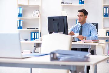 Handsome businessman employee sitting at his desk in office