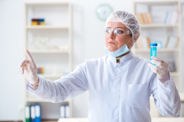 Woman chemist pressing virtual button in lab