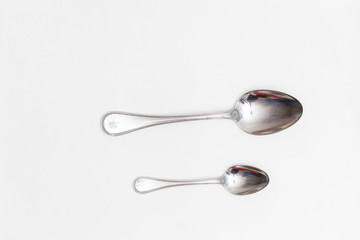 Set of a small and a big spoon on a white background in a studio