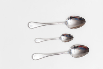 Set of small and big spoons on a white background in a studio