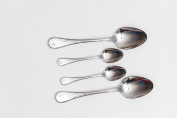 Set of small and big spoons on a white background in a studio