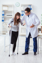 Fototapeta premium Doctor examining patient with broken leg