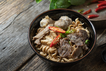 instant noodles in the black bowl on wooden background