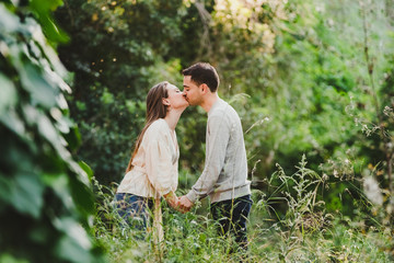 Enamored couple hugging and laughing in the middle of the green road