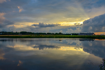 Sunbeams through retreating storm clouds form beautiful reflection in pond