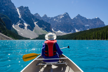 Woman paddling Canoe Moraine Lake Canada