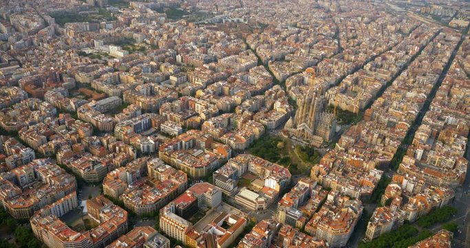 Aerial helicopter view of Barcelona Eixample district with Sagrada Familia and typical urban grid, Spain